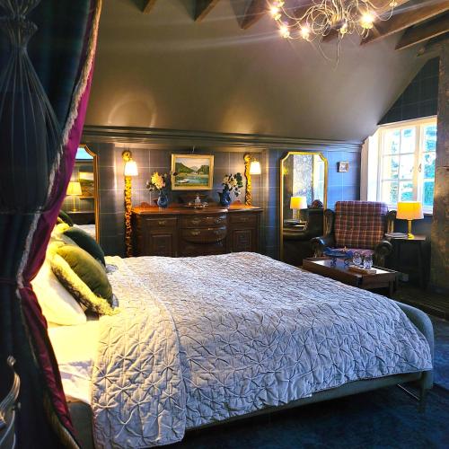 a bedroom with a king sized bed and a chair at Glencruitten House in Oban
