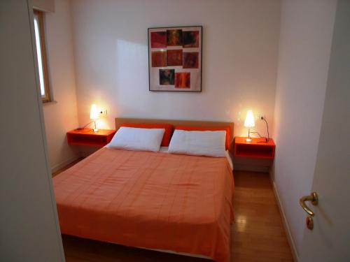 um quarto com uma cama e duas lâmpadas em duas mesas em Residence Mirage em Grado
