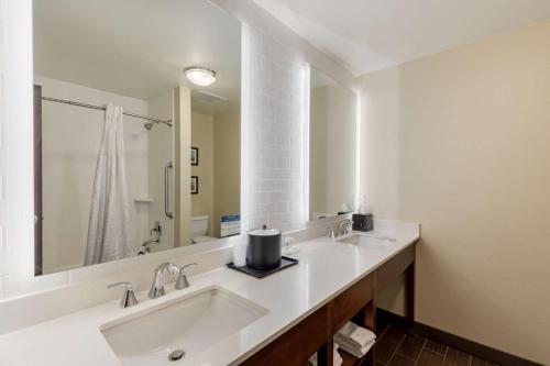 ein Badezimmer mit zwei Waschbecken und einem großen Spiegel in der Unterkunft Comfort Suites Loveland in Loveland