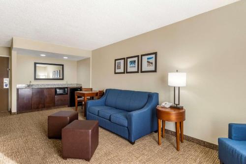 a living room with a blue chair and a table at Comfort Inn & Suites St Pete - Clearwater International Airport in Clearwater