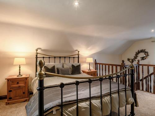 a bedroom with a bed and two night stands at Nightingale Lodge in Ropsley