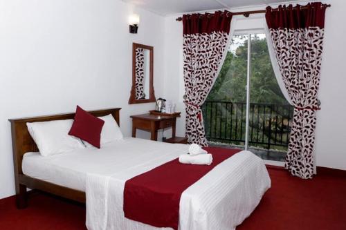 Sadhara River View Lodge في كاندي: غرفة نوم بسرير كبير ونافذة