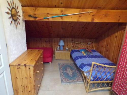 une chambre avec un lit dans une pièce en bois dans l'établissement Studio décor chalet jusqu'à 6 couchages, à Fontpédrouse
