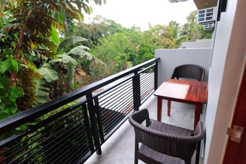 a balcony with two chairs and a table at Josefina's Tourist Inn in Busuanga