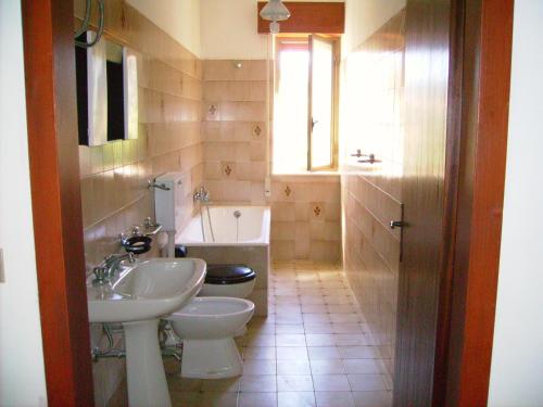a bathroom with a sink and a toilet and a tub at Casa Gelferraro in Calatafimi