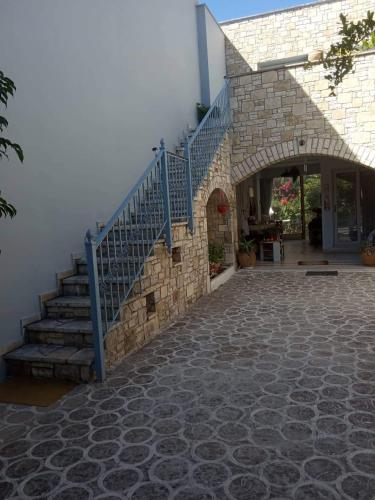 a stone building with a blue staircase next to a building at Πέτρινο στη θάλασσα in Nafpaktos
