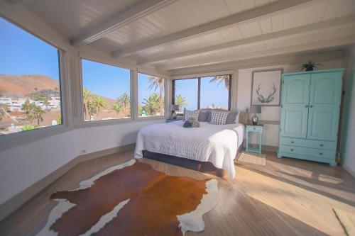 a bedroom with a bed in a room with windows at The Luxury Penthouse at Casita Palmera in Haría