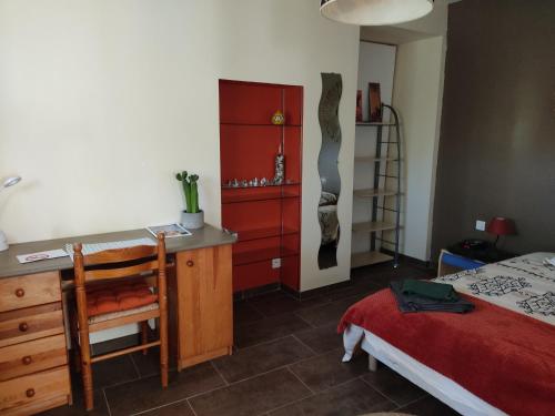 een slaapkamer met een bed, een dressoir en een bureau bij Chambre privée avec parking in Nîmes