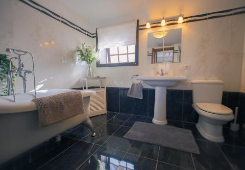 a bathroom with a tub and a sink and a toilet at The Luxury Penthouse at Casita Palmera in Haría