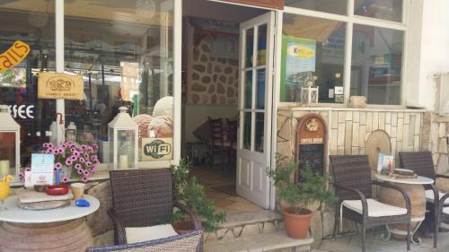 a restaurant with tables and chairs in front of a store at Kanoni Beach Apartments in Lákka