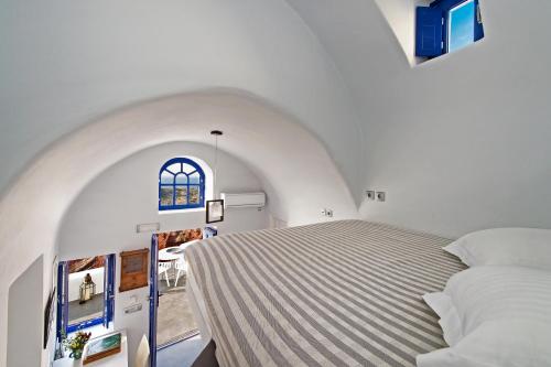 een slaapkamer met 2 bedden en een raam bij Domus Solis Luxury Villa in Oia