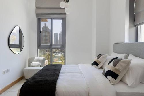 a white bedroom with a large bed and a chair at Dubai Marina, Two bedrooms apartment with full Marina View in Dubai