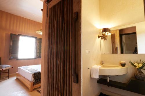 baño con lavabo, espejo y cama en Kasbah Flilou, en Aït Ougliff
