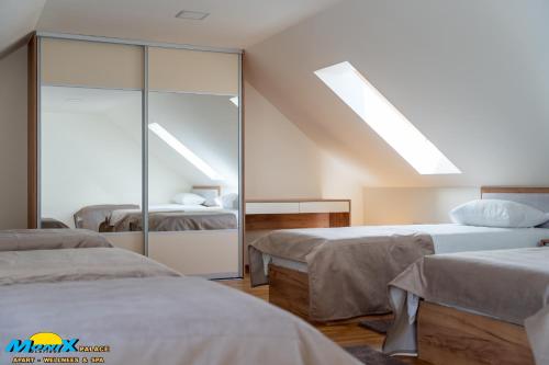 a bedroom with two beds and a mirror at Monix Palace Zlatibor in Zlatibor