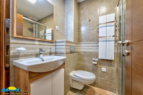 a bathroom with a sink and a toilet and a mirror at Monix Palace Zlatibor in Zlatibor