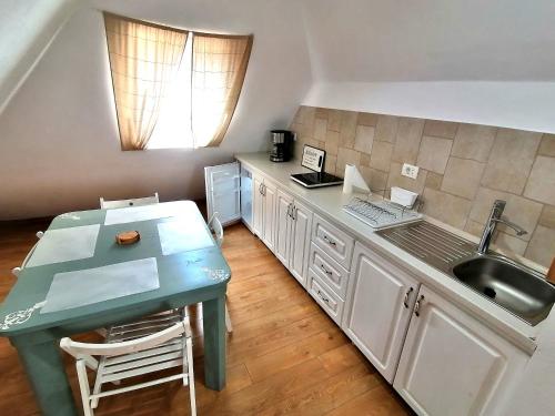 eine Küche mit einem grünen Tisch und einem Waschbecken in der Unterkunft Casa Bologna in Braşov