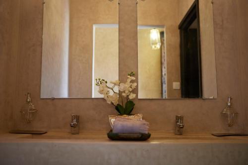 a bathroom sink with a vase of flowers on it at Kasbah Flilou in Aït Ougliff