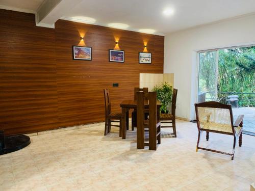 uma sala de jantar com mesa e cadeiras em Sadhara River View Lodge em Kandy