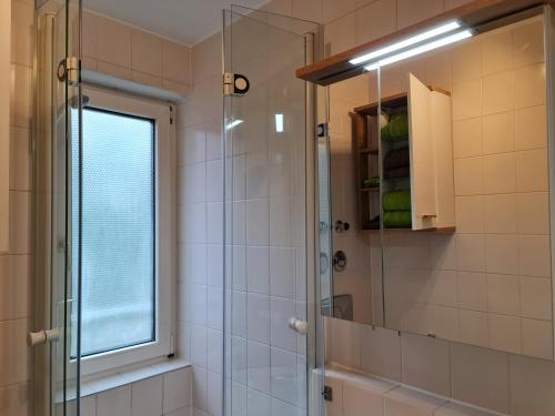 a bathroom with a shower with a glass door at City Appartement am Olympiapark in Munich