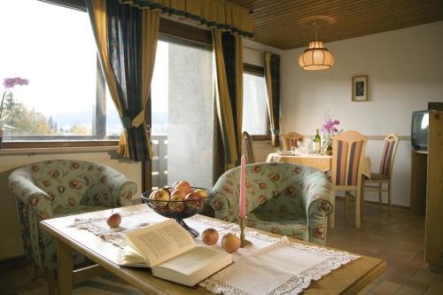 a room with a table with a bowl of fruit and a book at Haus Wandl in Seefeld in Tirol