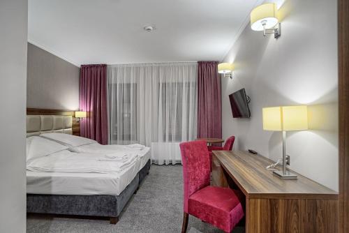 a hotel room with a bed and a desk at Hotel Kamieniczka in Legnica