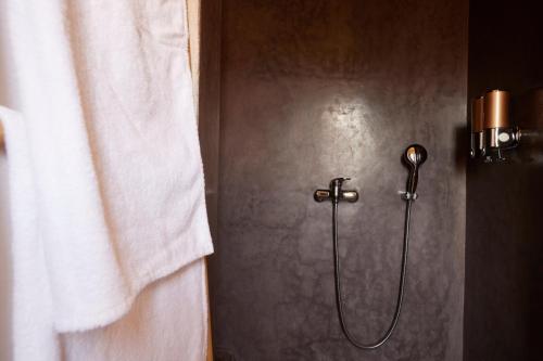 a shower with a hose in a bathroom at Kasbah Flilou in Aït Ougliff