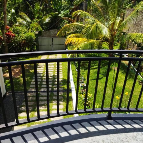 a black metal railing on a balcony with a yard at Edelweiss Residence in Hikkaduwa