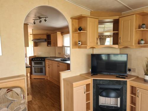 a kitchen with an archway with a fireplace in it at 8 berth central heated on Coral Beach ABI CB in Ingoldmells