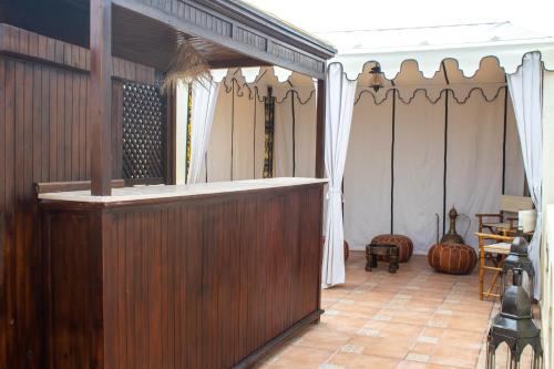 a wooden bar in a room with a table at Perlekech Riad & Spa in Marrakech