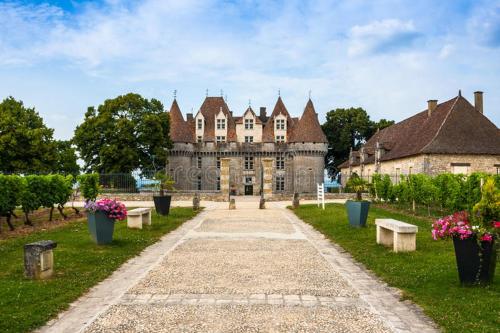 un viejo castillo con bancos delante de él en Cœur de vigne à Colombier 24560 en Issigeac