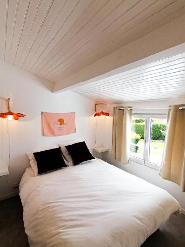 une chambre avec un grand lit blanc avec deux lampes dans l'établissement Little Casa Royan, à Royan
