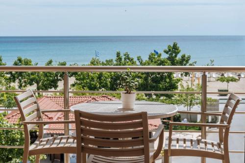 a table and chairs on a balcony with the beach at Hotel Giannoulis in Paralia Katerinis