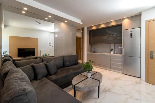 a living room with a large couch and a kitchen at Hotel Giannoulis in Paralia Katerinis
