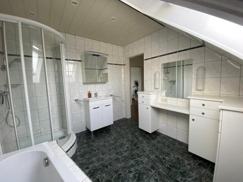 Baño blanco con lavabo y bañera en Moderne Wohnung in stadtnaher, dennoch ruhiger Lage en Nahe