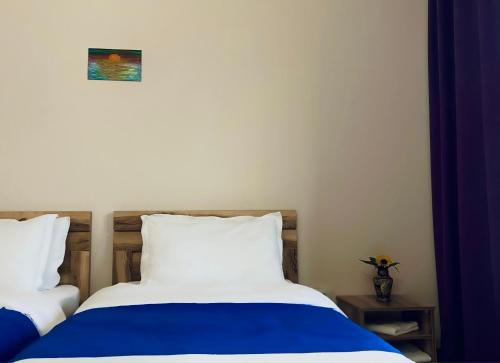 two beds in a room with blue and white at Cottage Kesane in Stepantsminda