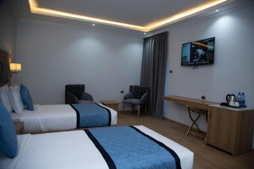 a hotel room with two beds and a flat screen tv at Aselefech Merga Hotel and Spa in Addis Ababa