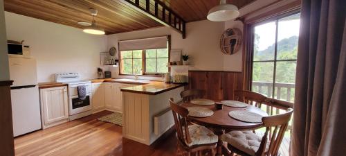cocina con mesa de madera, mesa y sillas en Tall Trees Eco Retreat, en Apollo Bay