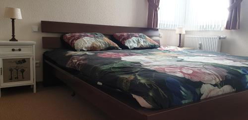 a bed with a colorful blanket and pillows on it at Vakantiewoning EvaLisa in Willingen