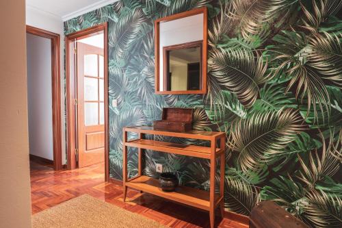 een kamer met een muur met een muurschildering van bladeren bij Apartmento Alcabre (Vigo) vistas al mar 6 personas in Vigo