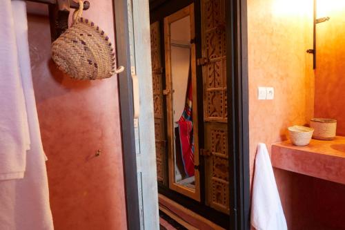 a hallway with a door to a bathroom with a towel at Kasbah Flilou in Aït Ougliff