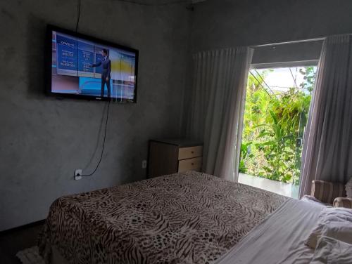 1 dormitorio con 1 cama y TV en la pared en Casa do Sossego en Brasilia