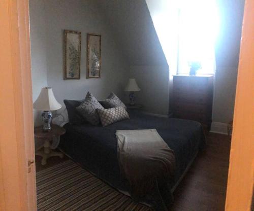a bedroom with a bed and two lamps and a window at Redefined Alchemy - Bright, eclectic, pretty Apt 3E in Little Falls