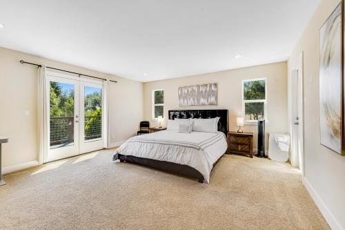 a large bedroom with a bed and windows at MeadowView on Darby in Sebastopol