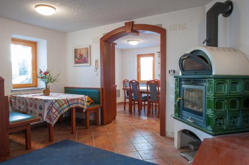 a living room with a green stove and a table at Holiday Home Zelenka in Cerklje na Gorenjskem