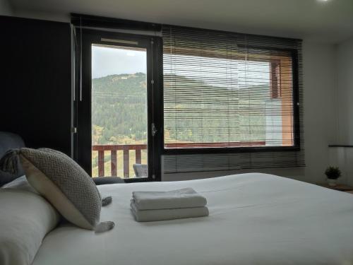 sypialnia z dużym białym łóżkiem i oknem w obiekcie AC Apartaments Bordes w mieście Bordes d´Envalira 