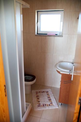 a bathroom with a toilet and a sink and a window at Quinta do Mineiro-Serra da Estrela in Matança