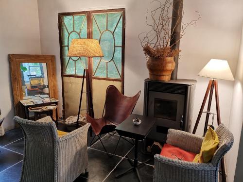 a living room with chairs a table and a fireplace at Eremyten Hof in Evergem