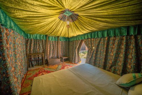 a bedroom with a bed with a canopy at Ouednoujoum Ecolodge & Spa in Ouarzazate