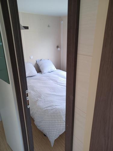 een slaapkamer met een bed in een kleine kamer bij Logement entier wifi stationnement gratuit in Voiron