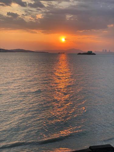 a sunset over a body of water with the sun setting at 大橋旁民宿 in Jincheng